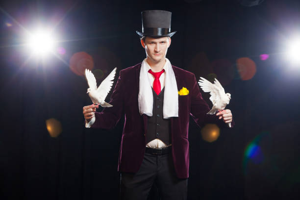 istock The magician with a two flying white Doves. on a black background 894962752