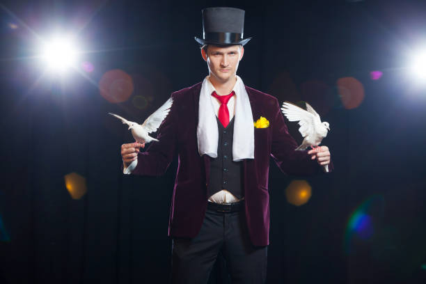 istock The magician with a two flying white Doves. on a black background 894962928
