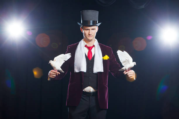 istock The magician with a two flying white Doves. on a black background 894963040