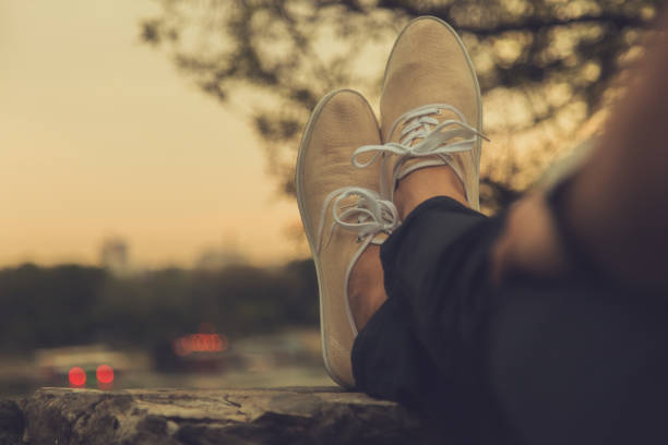 Man's shoes with distant city scape in twilight / dusk.