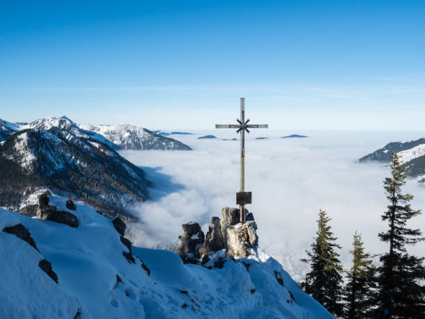 mountain summit cross above the fog in the valley - summit cross imagens e fotografias de stock