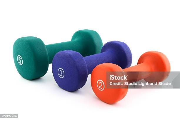 Foto de Três Colorida Halteres De Diferentes Size e mais fotos de stock de Colorido - Colorido, Levantamento de peso, Musculação com Peso