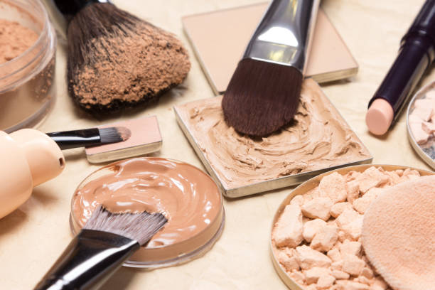Corrective makeup products and accessories close-up Foundation, powder, concealer with make-up brushes on crumpled paper. Corrective makeup products and accessories close-up, selective focus concealer stock pictures, royalty-free photos & images