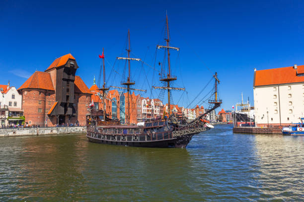 istock Pirate ship and historic port crane at Motlawa river 894977430