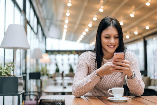istock Young woman in a modern cafe reading a text message 894977756