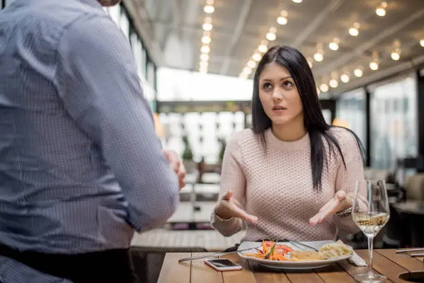 Photo of Portrait of woman complaining about food quality in restaurant.