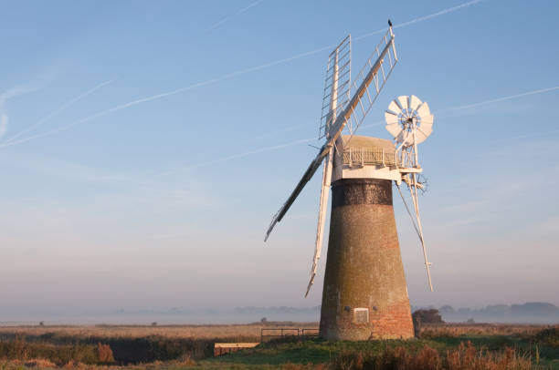 istock Restored windmill on misty morning under clear blue sky 894983236