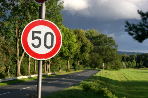Tempo 50 Straßenschild (Geschwindigkeitsbeschränkung) und Straße photo