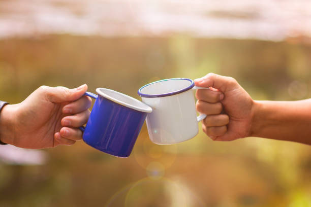 clink szklanki filiżankę kawy razem w środowisku naturalnym, rozmycie tła z flary słoneczne - clink zdjęcia i obrazy z banku zdjęć