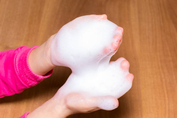 istock close up foam in two hand isolated on wood background. 894991642