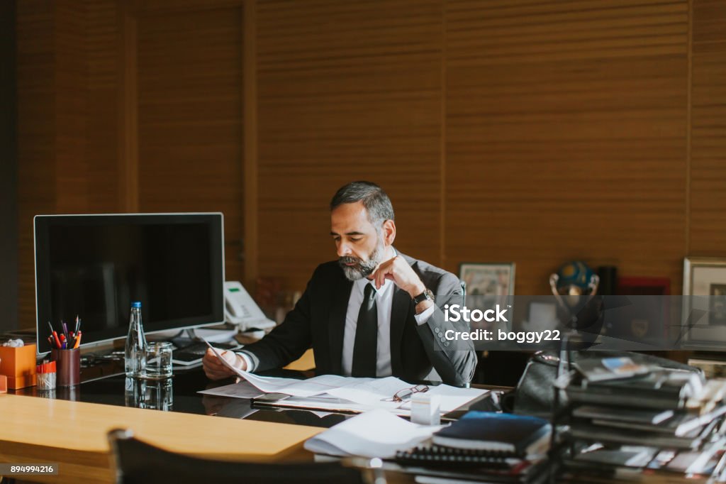 Senior businessman working on laptop in modern office Senior businessman working on laptop in modern office at desk CEO Stock Photo