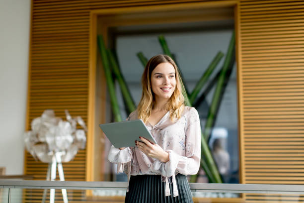 istock Young businesswoman standing with digital tablet in office 894994572