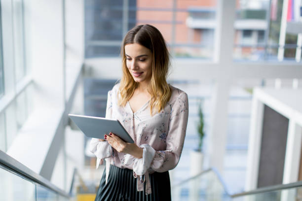 istock Young businesswoman standing with digital tablet in office 894994574