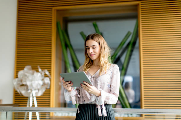 istock Young businesswoman standing with digital tablet in office 894994580
