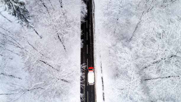 istock Road through wintery forest - aerial view 894999870