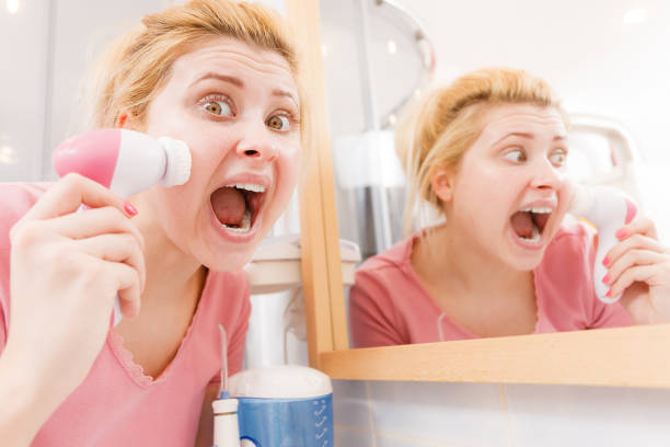 istock Shocked woman using facial cleansing brush 895000970
