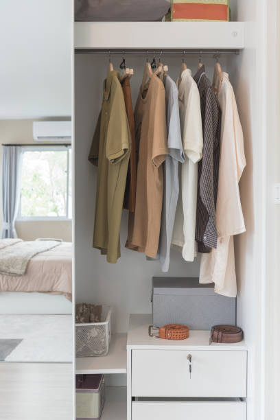istock wooden wardrobe with clothes hanging on rail 895015318