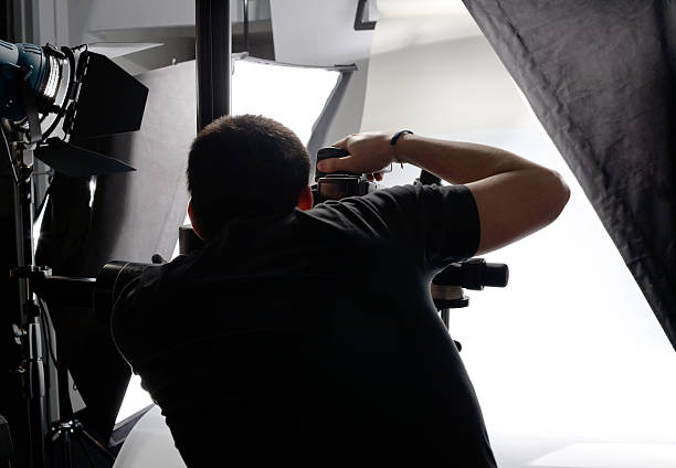 Professional Photographer From Behind Looking Through Viewfinder In Studio