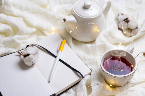istock Warm knitted plaid,cup of hot tea and notebook 895028506