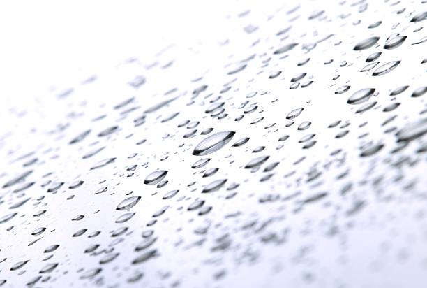 Abstract macro of rain drops on metal car surface.