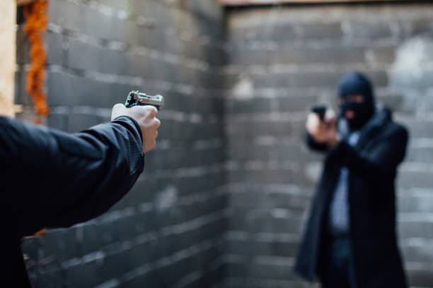 Two man pointing guns to each other's direction