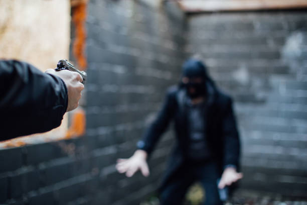 um homem apontando uma arma para outro homem, cujo rosto está coberto com uma tampa - gun handgun violence kidnapping - fotografias e filmes do acervo