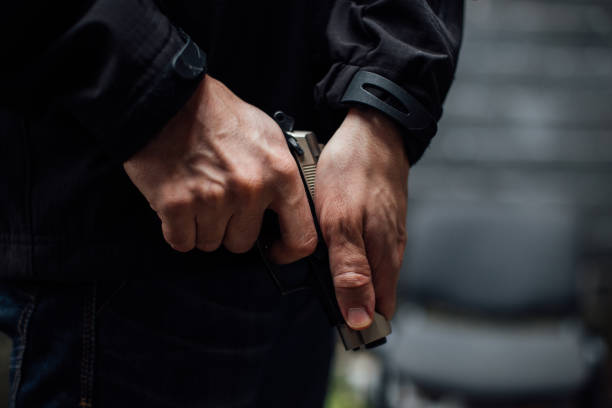 istock Man's hands holding a gun and preparing to shoot 895042088