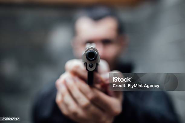 A Man Pointing A Gun At Lens Stock Photo - Download Image Now - Gun, Shooting a Weapon, Murderer