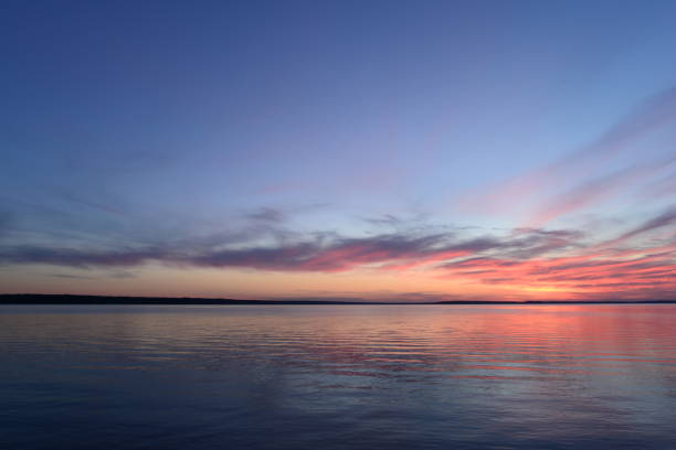 istock Sunset light in the clouds above the water surface 895045092