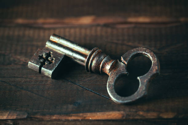 istock Vintage key on an old rough wooden background. Retro style 895051028