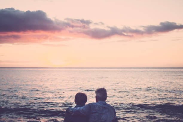 istock elderly couple on the beach at sunset 895063786