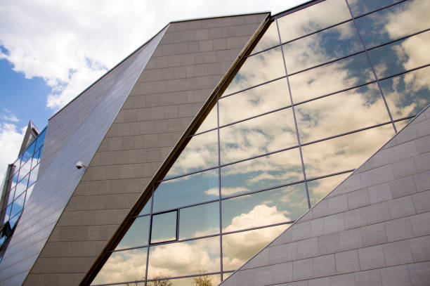 istock Perspective view of the modern building facade with clouds reflections on the windows 895068962