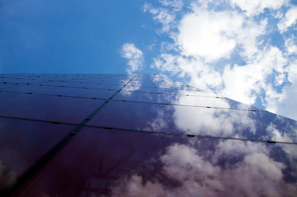 istock Perspective view of the modern building facade with clouds reflections on the windows 895072316