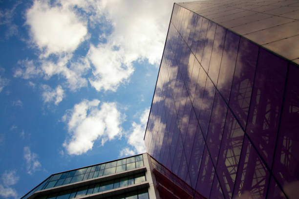 istock Perspective view of the modern building facade with clouds reflections on the windows 895072390
