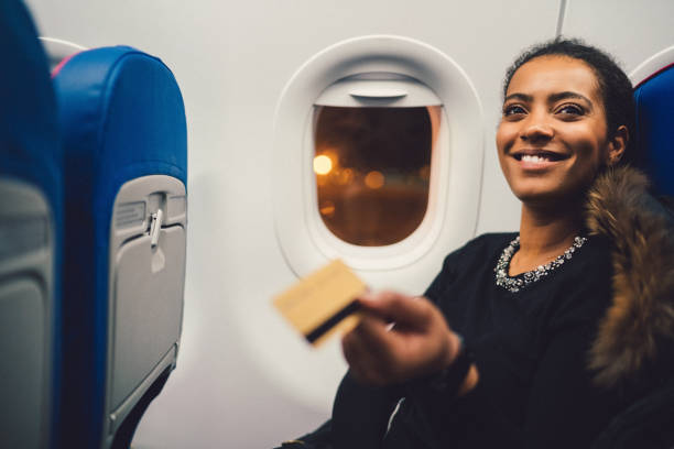 młoda kobieta w samolocie zakupy z kartą kredytową - commercial airplane airplane business travel flying zdjęcia i obrazy z banku zdjęć