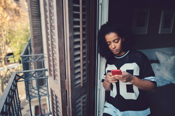 Unhappy woman texting at the balcony