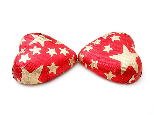Couple of star-patterned chocolate hearts "kissing" stock photo