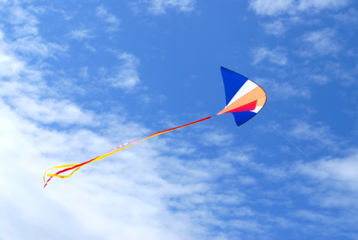 Colorful kite against cloudy sky