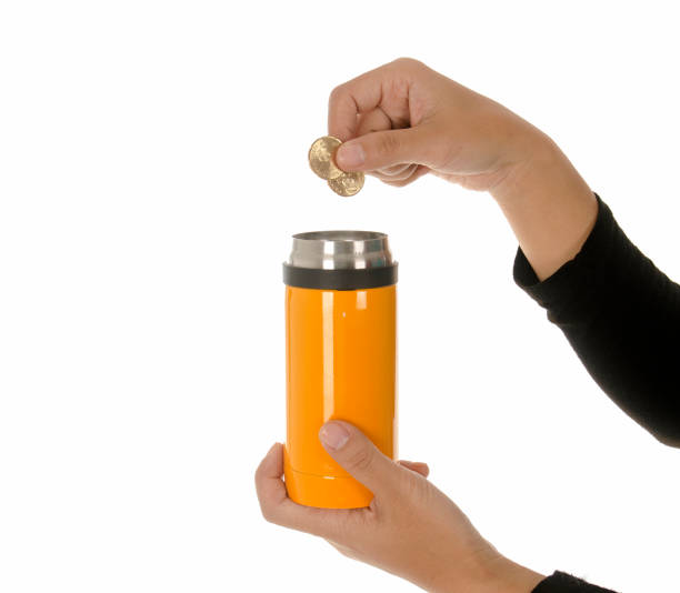 istock Hand insert coins into piggy bank isolated white background 895095978