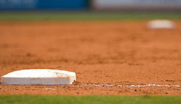 terrain de baseball à un match de baseball - baseball base baseball diamond field photos et images de collection