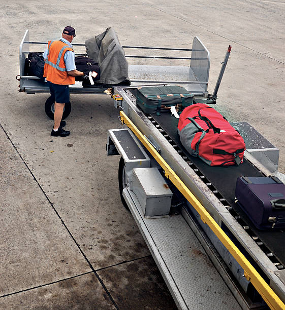Man loading luggage onto a plane stock photo