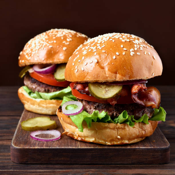 istock Homemade hamburger with beef, fried bacon, onion, tomato, lettuce and marinated cucumber 895100876