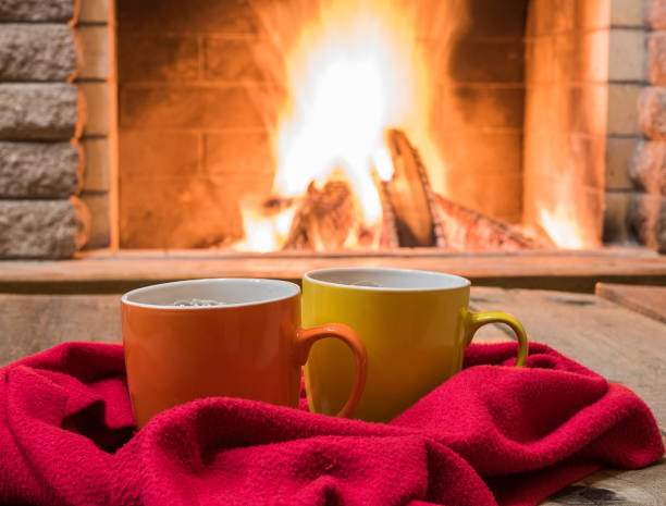 istock Two  mugs  for tea or coffee,  woolen things near  cozy fireplace. 895101014