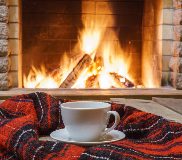istock Cup of tea and sugar,  woolen things near  cozy fireplace. 895101036