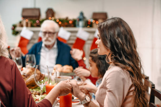 istock family praying before christmas dinner 895114428