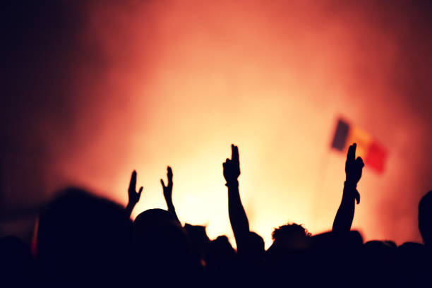 istock Crowd at a music concert, audience raising hands up 895119680