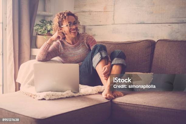 Woman On Sofa Working At The Comuter Stock Photo - Download Image Now - Tranquility, Women, 40-44 Years