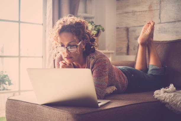 istock woman on sofa working at the comuter 895129842