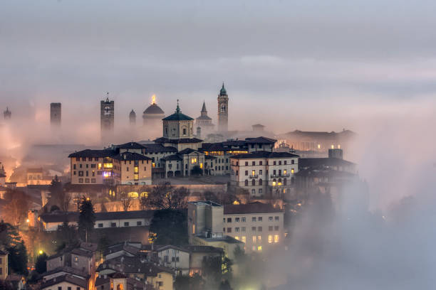 misty embrace the fog slowly envelops the Upper Town bergamo stock pictures, royalty-free photos & images