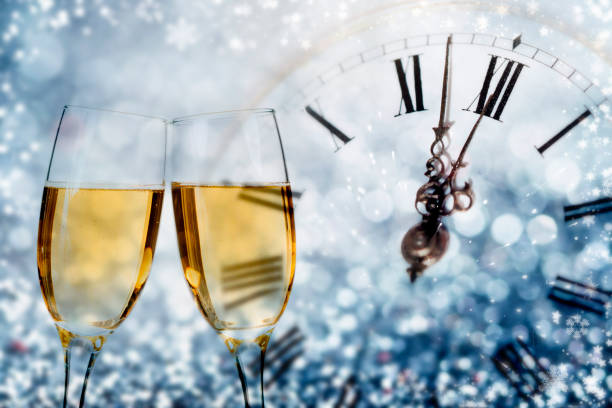 istock Champagne and clock on sparkling background 895138234